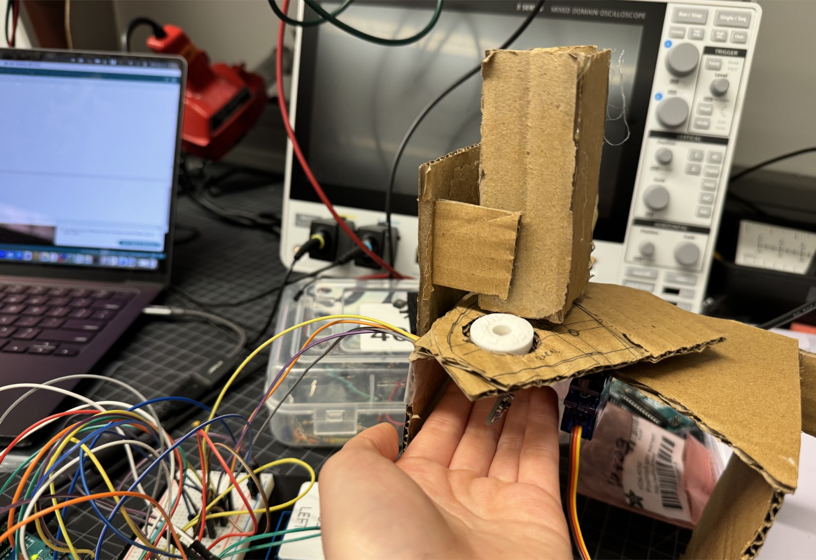 The servo mechanism mid-rotation at roughly 45 degrees, held in a hand.
