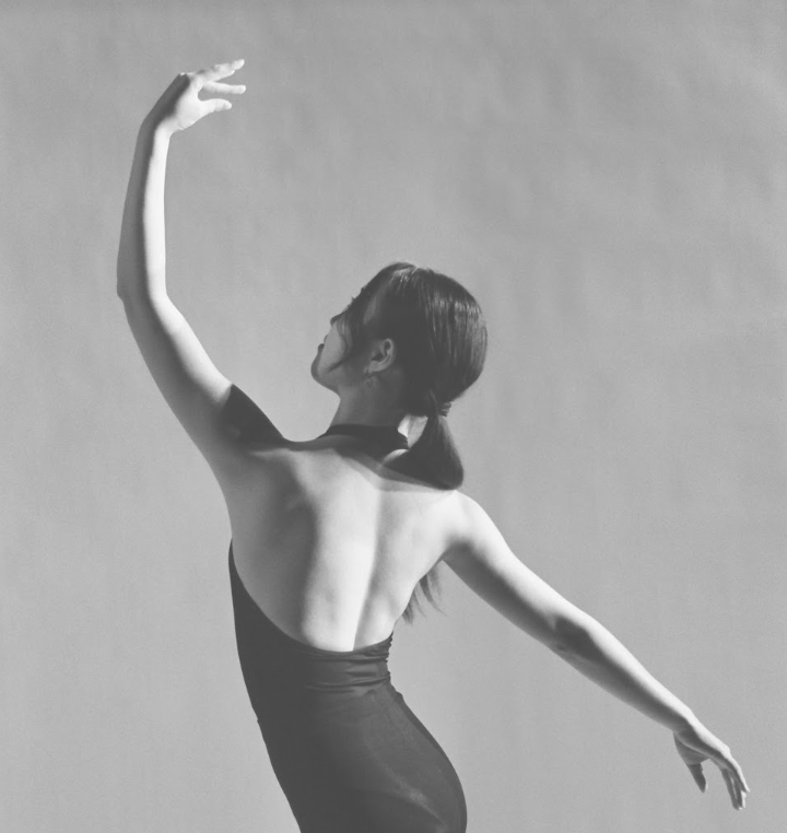 Lucy Park mid-movement in a dance rehearsal, arm raised.